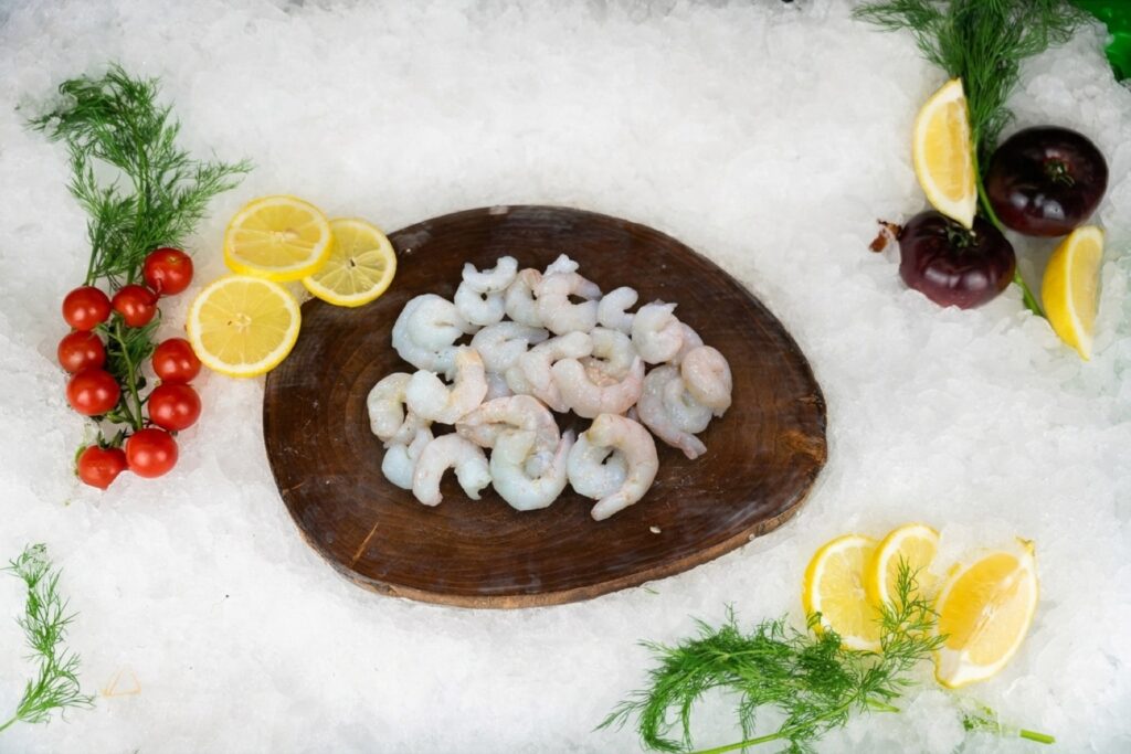 Colas frescas de Gamba Blanca del Mediterráneo peladas sobre tabla rústica en Puerto Cabrera